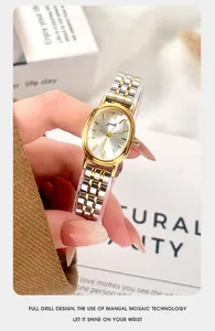 Close-up of a vintage oval quartz watch with a two-tone steel band held by hand