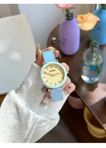 Close-up of GCCLIYO minimalist women quartz watch featuring a light blue fabric strap