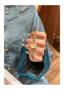 Detailansicht der eleganten SKHL-Gold-Vintage-Damenuhr vor einem blauen Seidenhintergrund