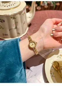 Detaillierte Makroansicht einer vintage SKHL Gold Uhr für Damen am Handgelenk beim Tee.