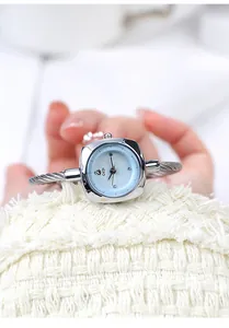 Elegante primer plano de un reloj GEDI para mujer con esfera azul claro y brazalete de cable plateado