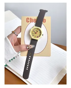 Close-up of a dopamine-style student quartz watch with colorful cartoon dial and grey strap.