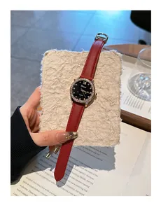 Detalle macro del reloj de moda Dimini con esfera estrellada y correa de cuero rojo vivo