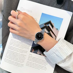 Elegante Eyki Damen-Quarzuhr mit silbernem Stahlband und schwarzem Zifferblatt am Handgelenk.
