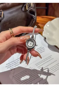 Close-up detail of silver rhinestone watch with adjustable drawstring strap.