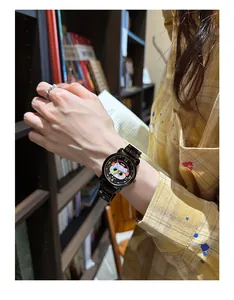 Détail d'une montre chat mignonne avec nœud noir et bracelet en acier sur un poignet féminin
