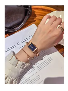 Close-up of elegant rose gold rectangular watch with blue starry dial and bracelet