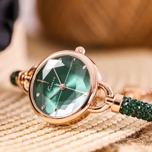 Close-up of elegant rose gold watch featuring a faceted green gemstone-like dial.