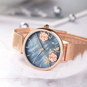 Close-up of rose gold women's quartz watch with elegant blue floral dial and mesh band.