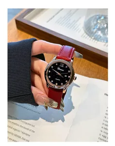 Detalle del reloj de mujer Dimini con esfera de cielo estrellado y correa de cuero roja.