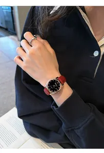 Vista detallada de un elegante reloj de mujer con esfera de cielo estrellado y correa roja