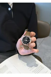 Primer plano del reloj Dimini con esfera de cielo estrellado y correa de cuero en marrón