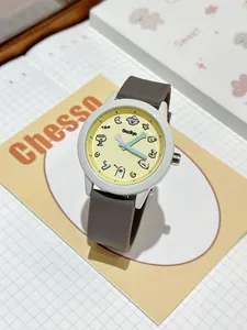 Primer plano de un lindo reloj de cuarzo de dibujos animados con esfera amarilla y correa marrón