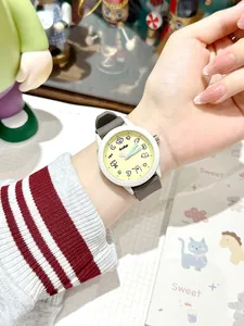 Lindo reloj de cuarzo con esfera amarilla y correa de silicona gris en la muñeca.