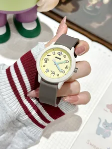 Primer plano de un lindo reloj de cuarzo con esfera amarilla y correa de silicona gris