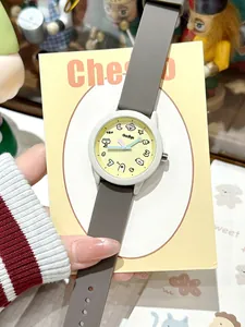 Primer plano de un reloj de cuarzo de dibujos animados con esfera amarilla y correa gris