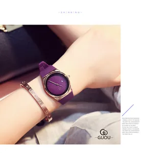 Close-up of a stylish purple GUOU quartz watch worn with a gold screw-motif bracelet.