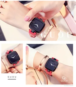 Detailansicht der GUOU Uhr mit schwarzem Zifferblatt und rotem Lederarmband am Handgelenk.