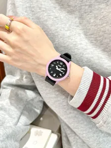 Primer plano de un lindo reloj de cuarzo morado con una correa de silicona negra