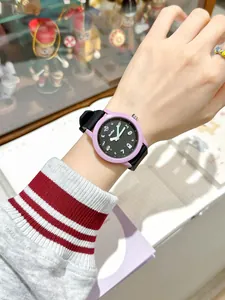 Primer plano de un lindo reloj de cuarzo con bisel púrpura y correa de silicona negra