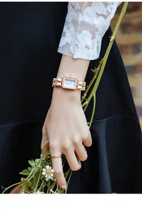 Close-up of Gedi women's watch with rose gold rectangular case and woven chain strap