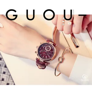 Gros plan d'une montre GUOU pour femme portée au poignet avec un bracelet nœud doré