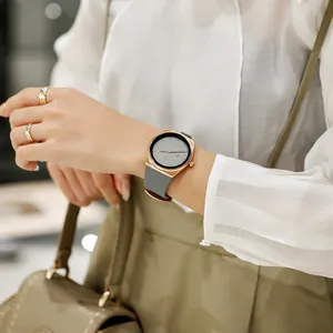 Elegant minimalist grey quartz watch with rose gold case on an elegant woman's wrist