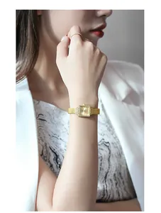 Close-up of elegant gold square ladies watch with crystal bezel worn on the wrist