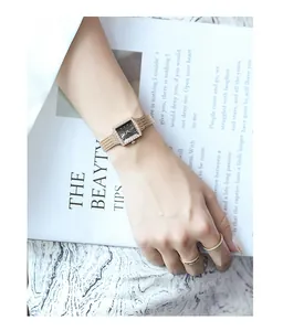 Elegant gold mesh strap square watch for ladies with rhinestone bezel worn on wrist