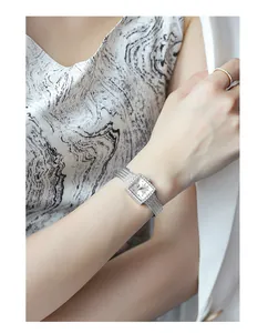 Elegant silver ladies square watch with rhinestone bezel and mesh band on wrist