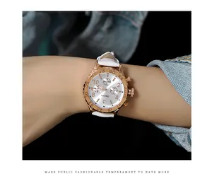 GUOU women's quartz watch with rose gold case and white leather strap worn on wrist