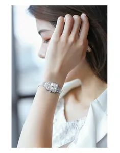 Elegant square silver quartz watch with rhinestone bezel on female wrist detail view.
