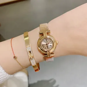 Elegant DINIMI gold women's quartz watch with a round face and Roman numeral dial
