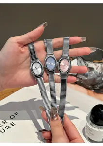 Close-up of GEKI oval quartz watches with stretch bands in silver, blue, and pink.