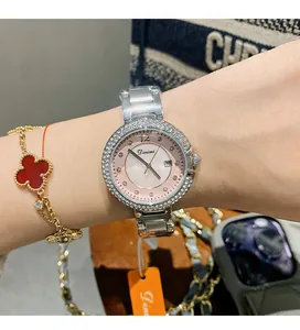 Nahaufnahme einer eleganten Damenuhr mit Strass-Lünette, rosa Zifferblatt und Datum.