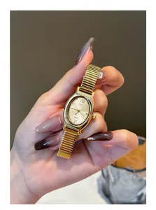 Detailed close-up of a minimalist gold oval quartz watch for women with a ribbed metal band