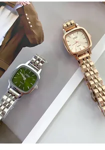 Close-up of GEDI women's square quartz watches in green and rose gold with steel bands.