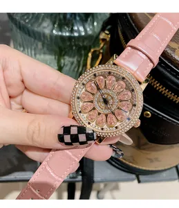 Gros plan sur l'élégante montre en cuir rose avec un cadran en cristal étincelant.