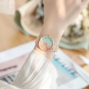 Elegant women's rose gold mesh watch with green and orange gradient dial on wrist