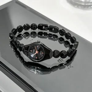 Detailed close-up of GEDI black luxury alloy bracelet watch on mirror surface