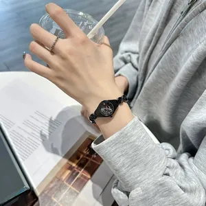 Detailed macro shot of GEDI elegant small black quartz bracelet watch on lady's wrist