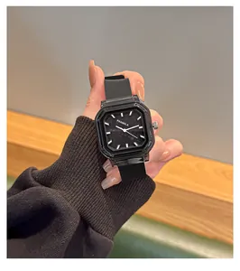 Primer plano de un elegante reloj de cuarzo cuadrado negro con correa de silicona.