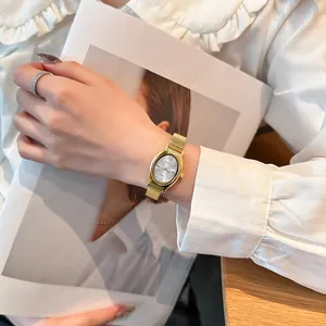 Elegant gold oval quartz watch for women with mesh band shown in a lifestyle setting