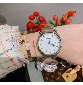 Close-up of minimalist women's quartz watch with date display and white shell dial
