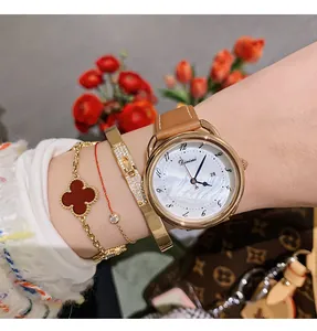 Elegant women's quartz watch with pearl dial and leather strap, styled with bracelets