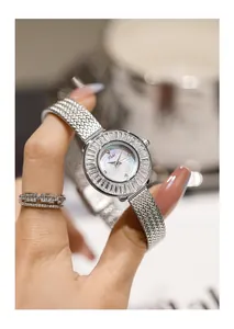Primo piano di un elegante orologio da donna al quarzo con ghiera di strass e cinturino mesh