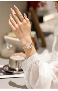 Vista dettagliata dell'orologio al quarzo con strass oro rosa e cinturino mesh al polso.