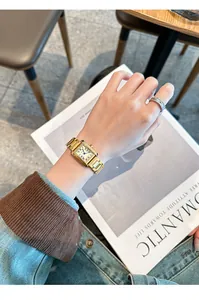 Close-up of a vintage GUOU gold square steel band quartz watch worn on the wrist