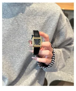 Close-up of GUOU vintage square watch featuring gold finish and black leather strap