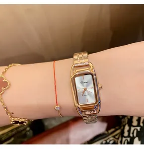 Close-up of Dinimi rose gold quartz watch with rectangular dial on woman's wrist